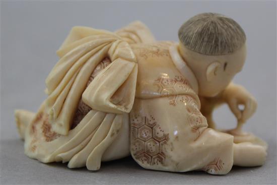 A Japanese carved ivory okimono of a child with a spinning top, 19th century, 17.6cm